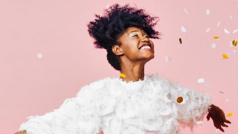 Une femme souriante lance des confettis