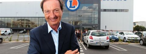 Leclerc Michel Edouard Leclerc posant devant un magasin Leclerc, avec le sourire