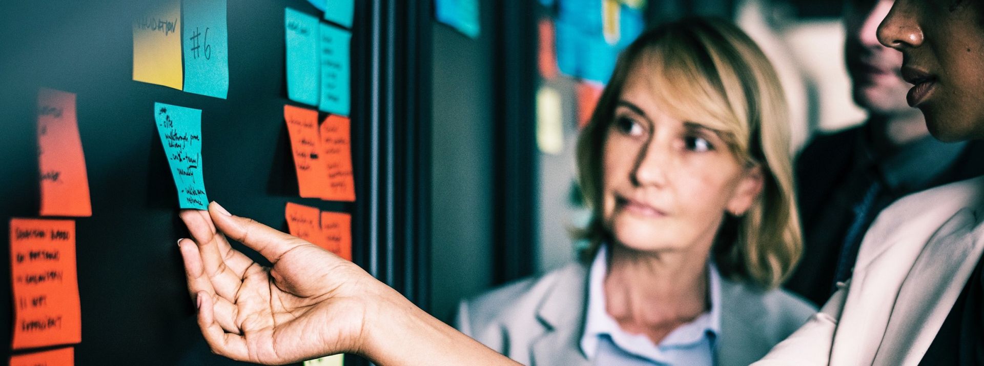 méthode agile post-it salariés devant un tableau de post-it travaillant en méthode agile