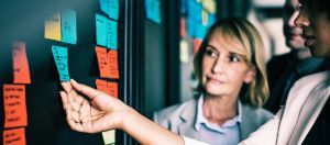 salariés devant un tableau de post-it travaillant en méthode agile