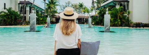AccorHotels met en place une charte pour travailler avec les influenceurs Une femme blonde assise de dos au bord d'une piscine