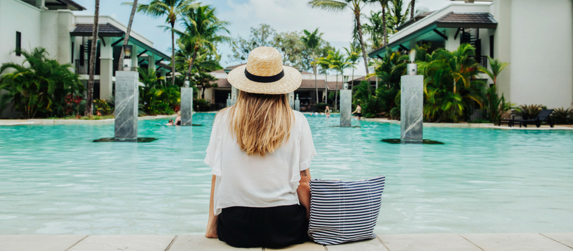 AccorHotels met en place une charte pour travailler avec les influenceurs Une femme blonde assise de dos au bord d'une piscine
