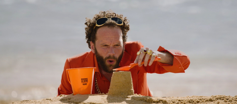 Sixt lance un concours de château de sable un homme qui fait un château de sable à la plage