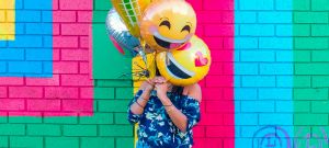 Une femme avec des ballons en forme d'emoji