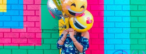 Quels sont les emojis préférés des Français ?  Une femme avec des ballons en forme d'emoji