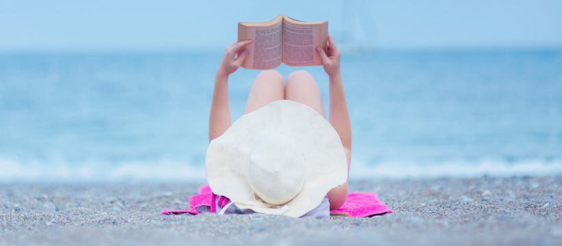 Quels livres lire cet été ? Une femme allongée sur la plage en train de lire un livre