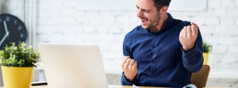 Pourquoi vous allez devoir recruter un chief reputation officer Un jeune homme en train de se réjouir derrière son ordinateur portable