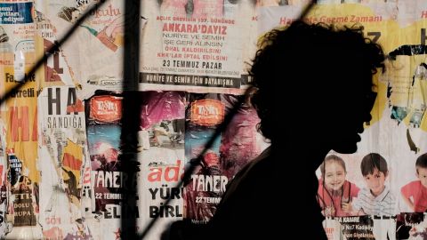 une ombre devant un mur d'affiches