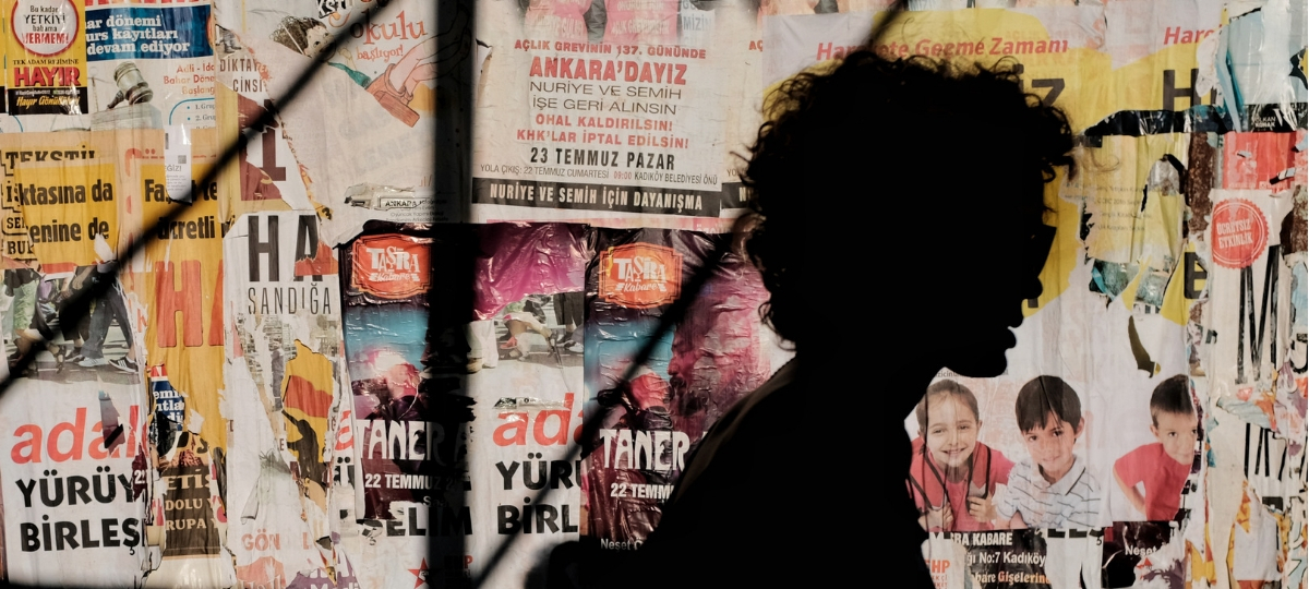 Fake news : et si les marques devenaient responsables ? une ombre devant un mur d'affiches