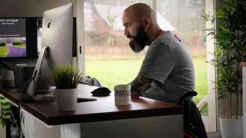 un homme en fauteuil roulant devant un ordinateur