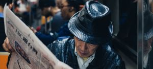 un homme lit le journal dans les transports