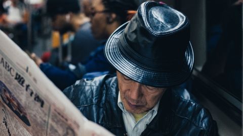 un homme lit le journal dans les transports