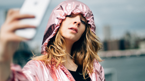 influenceuse prenant un selfie sous la pluie
