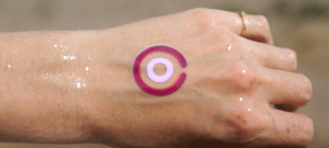 Une main avec un tatouage violet dessus.