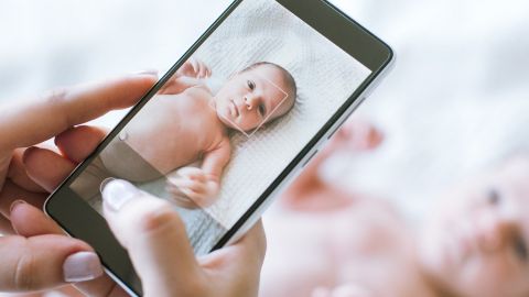 Bebe avec un smartphone qui le prend en photo