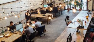 un open space avec des bureaux en bois et des guirlandes lumineuses