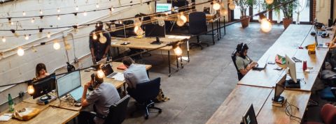 Les bureaux ont un impact sur la productivité et le bien-être des employés un open space avec des bureaux en bois et des guirlandes lumineuses