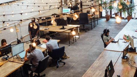 un open space avec des bureaux en bois et des guirlandes lumineuses