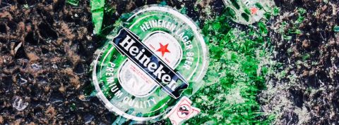 Bouteille de bière Heineken verte brisée sur la plage