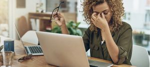 Une jeune femme métisse en train de s'énerver devant un ordinateur