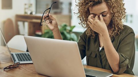 Une jeune femme métisse en train de s'énerver devant un ordinateur