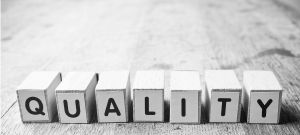 Le mot qualité présenté en petits cubes noir et blanc