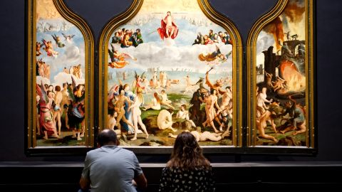 deux personnes face à un tableau dans un musée