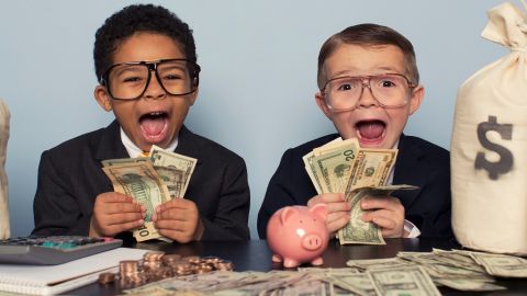 Deux enfants tenant des liasses de billets