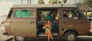 Une femme regarde son téléphone dans son van