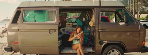 Les nouveautés Adobe qui vont faciliter la vie des créatifs Une femme regarde son téléphone dans son van