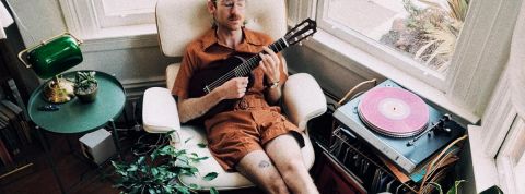 Parfois, pour être le meilleur... Il faut en faire le moins possible Un homme en train de se prélasser dans un fauteuil avec une guitare