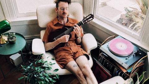 Parfois, pour être le meilleur... Il faut en faire le moins possible Un homme en train de se prélasser dans un fauteuil avec une guitare