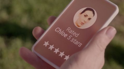 une main tient un téléphone portable avec un système de notation