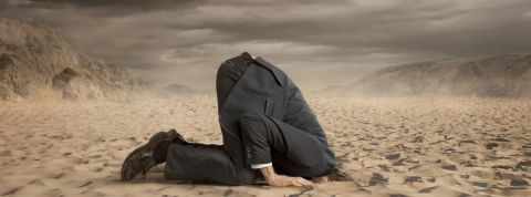 Les community managers de Monoprix et IKEA ratent leur communication de crise Un homme en costume enfonçant sa tête dans le sable