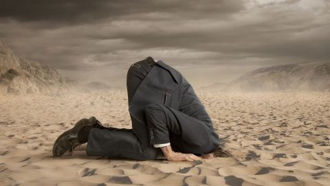 Les community managers de Monoprix et IKEA ratent leur communication de crise Un homme en costume enfonçant sa tête dans le sable