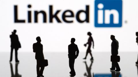 Des hommes et des femmes marchant devant le logo LinkedIn