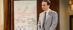 Sheldon Cooper, de la série Big Bang Theory, en costume devant un tableau