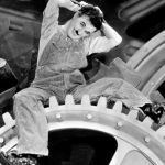Charlie Chaplin dans Les Temps Modernes sur un rouage d'usine