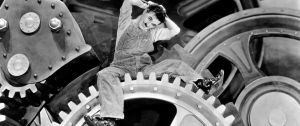 Charlie Chaplin dans Les Temps Modernes sur un rouage d'usine