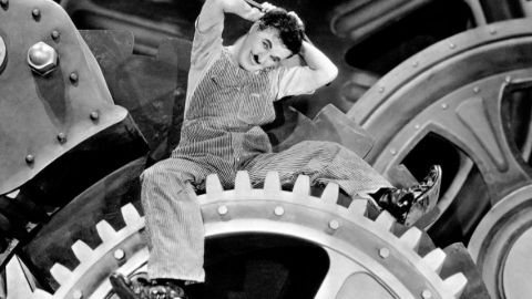 Charlie Chaplin dans Les Temps Modernes sur un rouage d'usine