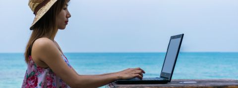 Où travailler quand on est un digital nomad ? Une femme en train de travailler au bord de la mer