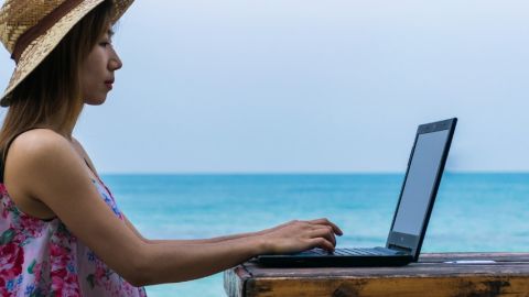 Une femme en train de travailler au bord de la mer