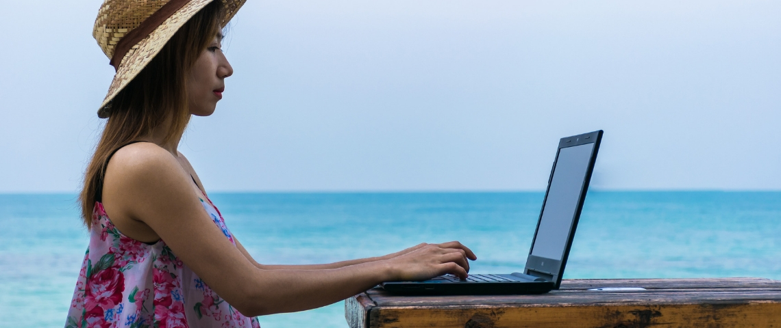 Où travailler quand on est un digital nomad ? Une femme en train de travailler au bord de la mer