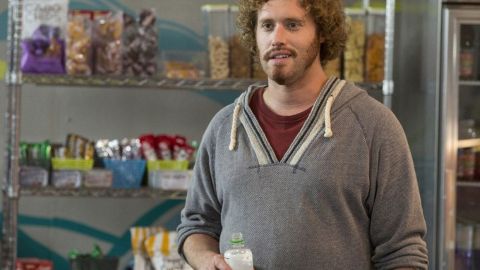 Erlich Bachman, dans la série Silicon Valley, en train de boire une boisson devant un stand de nourriture