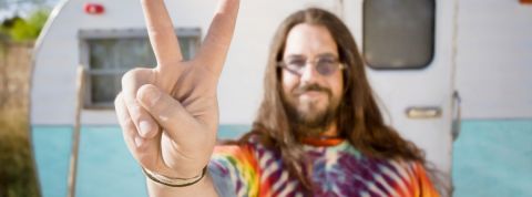 Non la drogue n'est pas que pour les hippies Un hippie devant une caravane en train de faire le signe peace