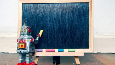 un robot devant un tableau noir
