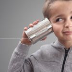 Un enfant avec une boîte de conserve sur l'oreille