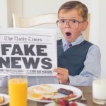 un enfant étrange lit le journal le matin au petit déjeuner