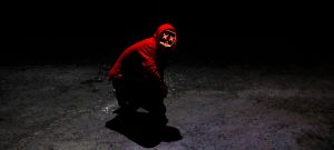 homme sans visage capuche rouge sur fond noir