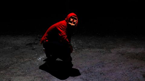 homme sans visage capuche rouge sur fond noir